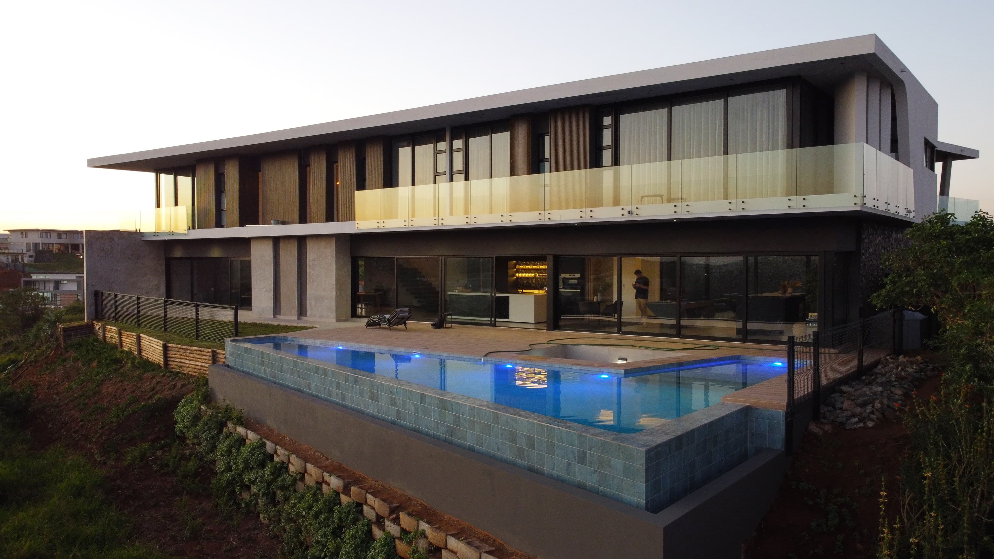 Daytime view of a contemporary home's pool terrace and landscaping