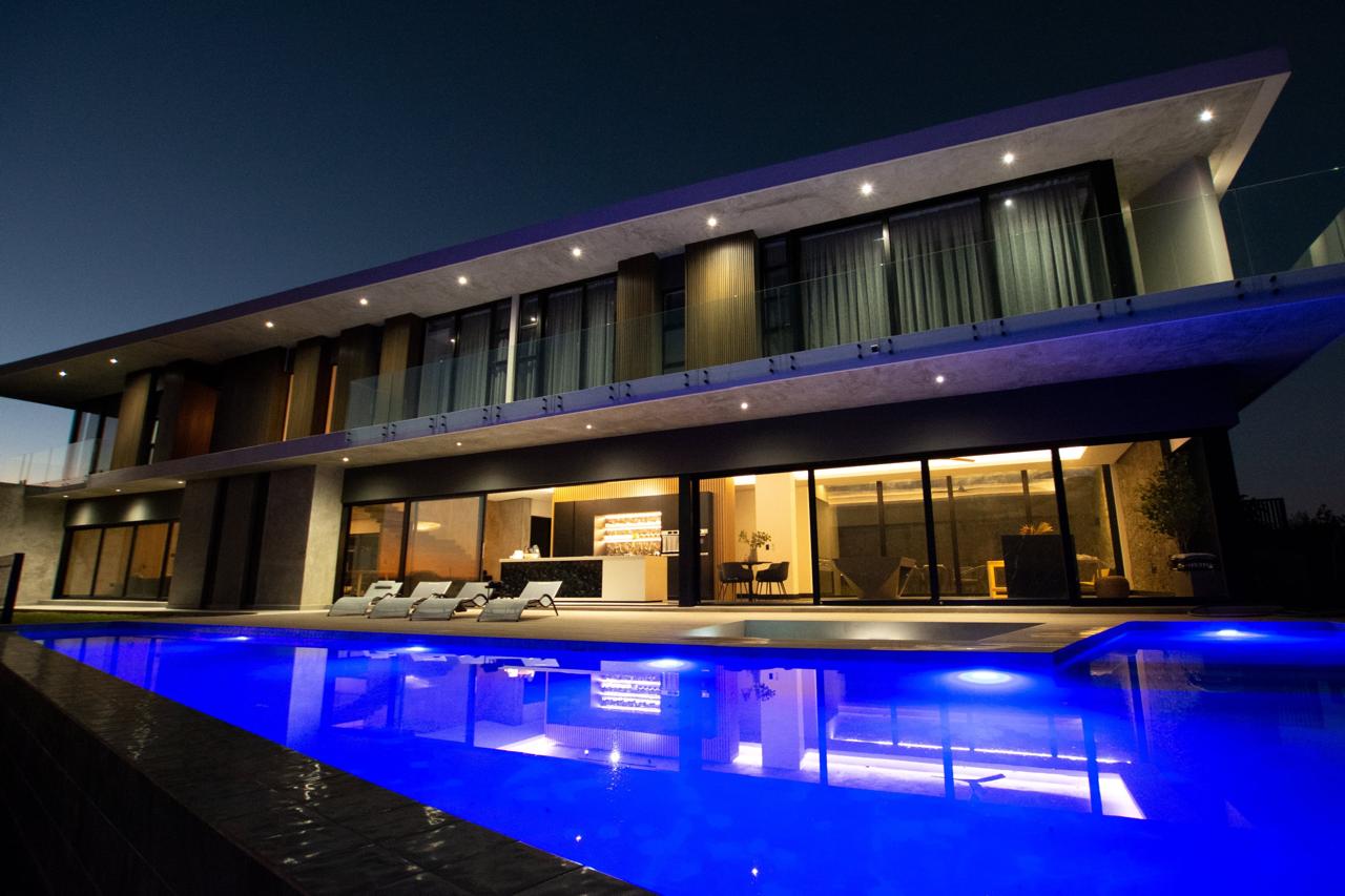 Contemporary home with an illuminated pool terrace at night