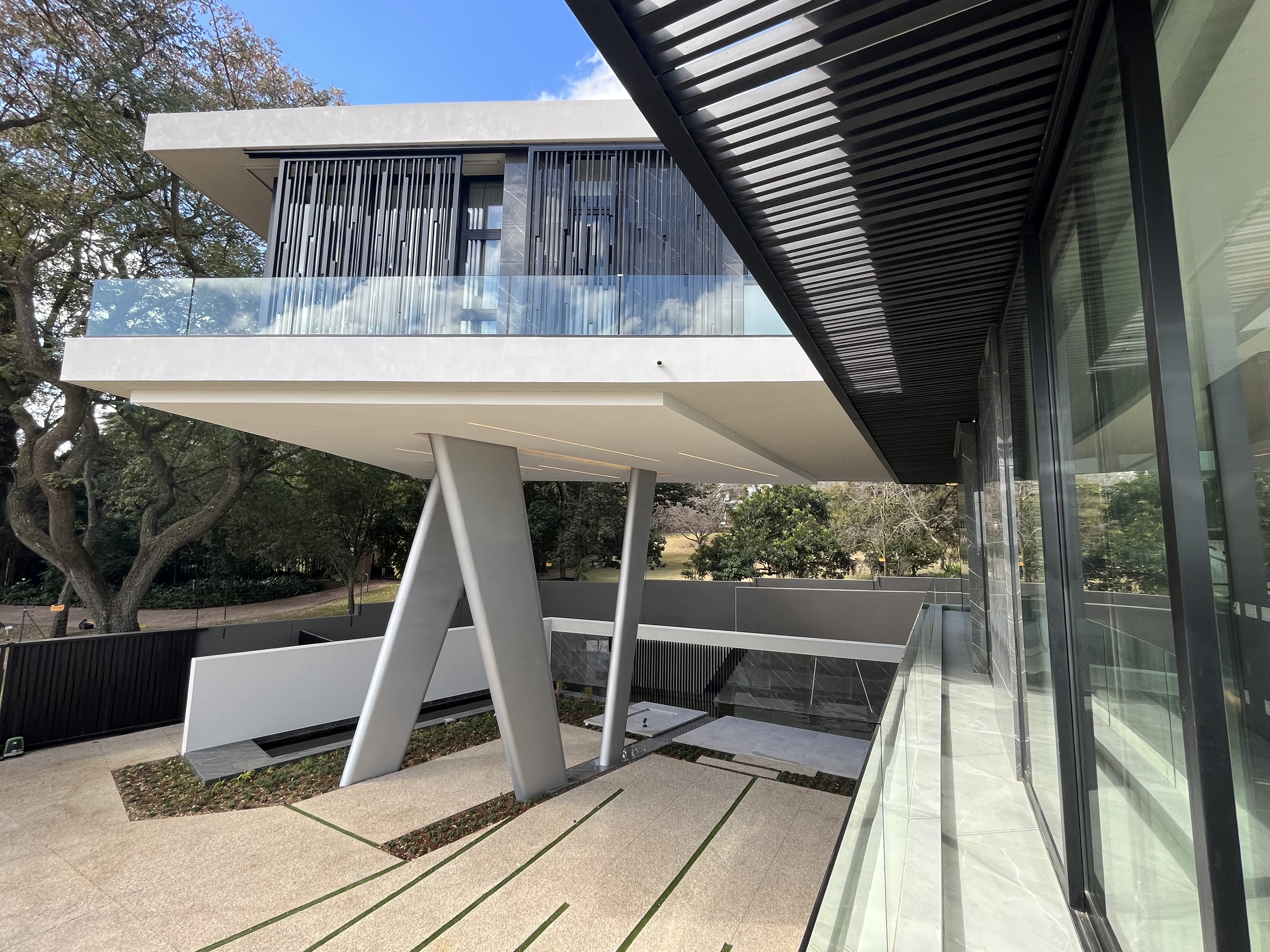 First-floor deck with glass balustrade and louvre screens