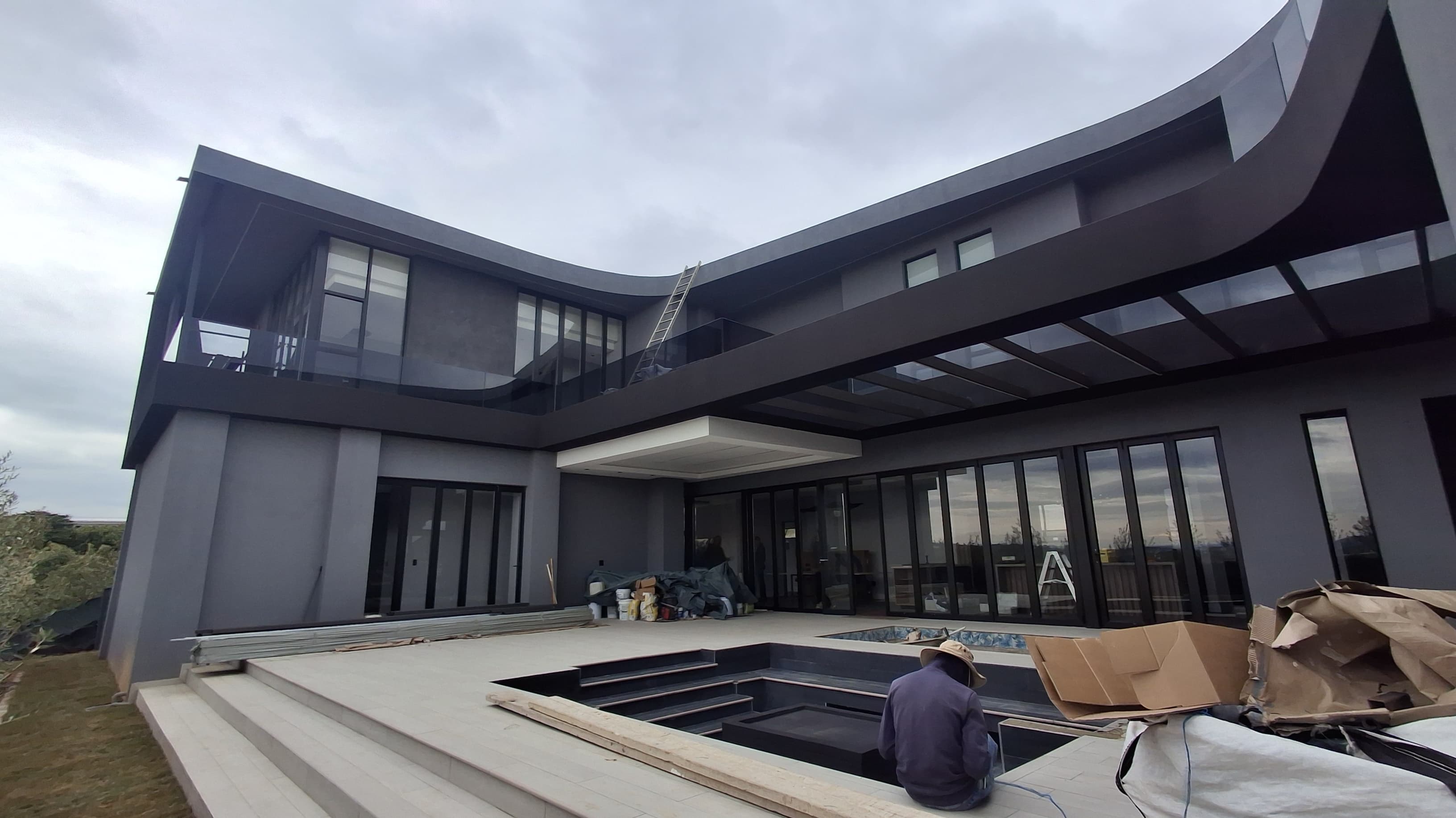Curved dark-cladded home under construction