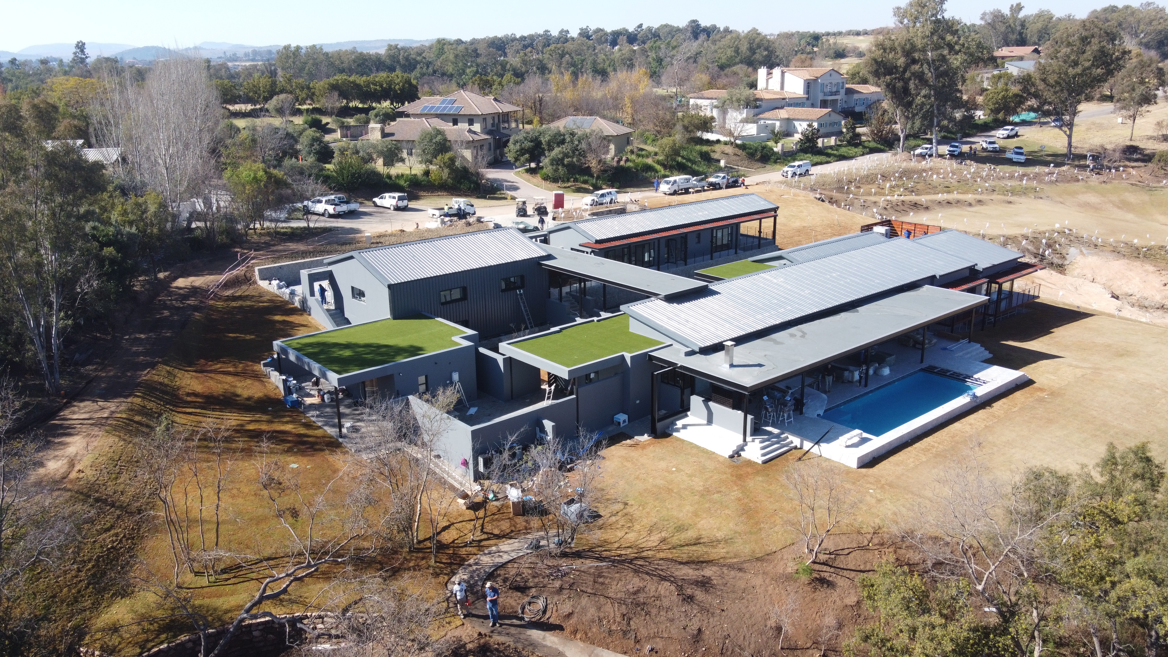 Aerial of a green-roof home with integrated pool structure