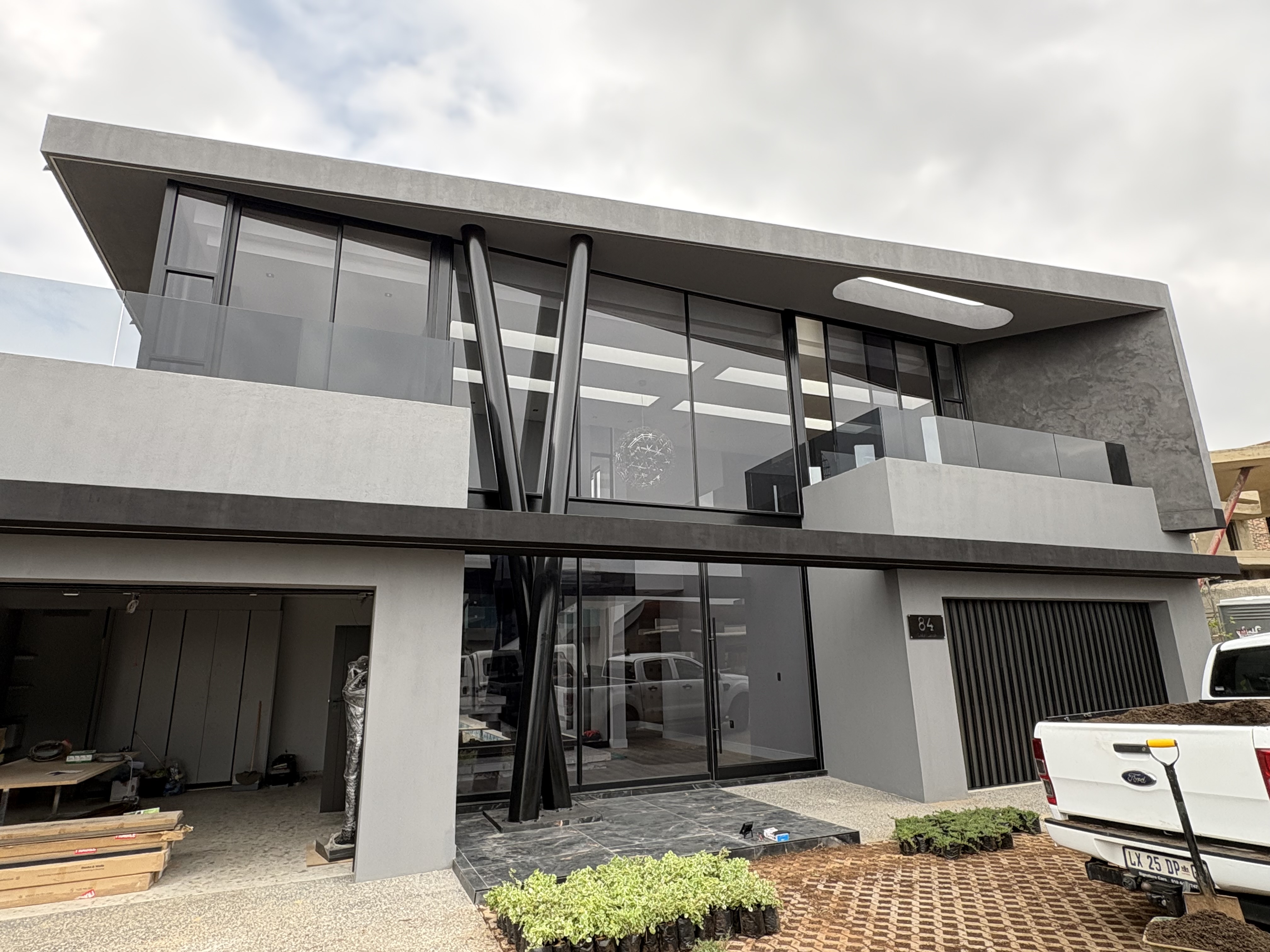 Grey rendered two-storey home with full-height glazing